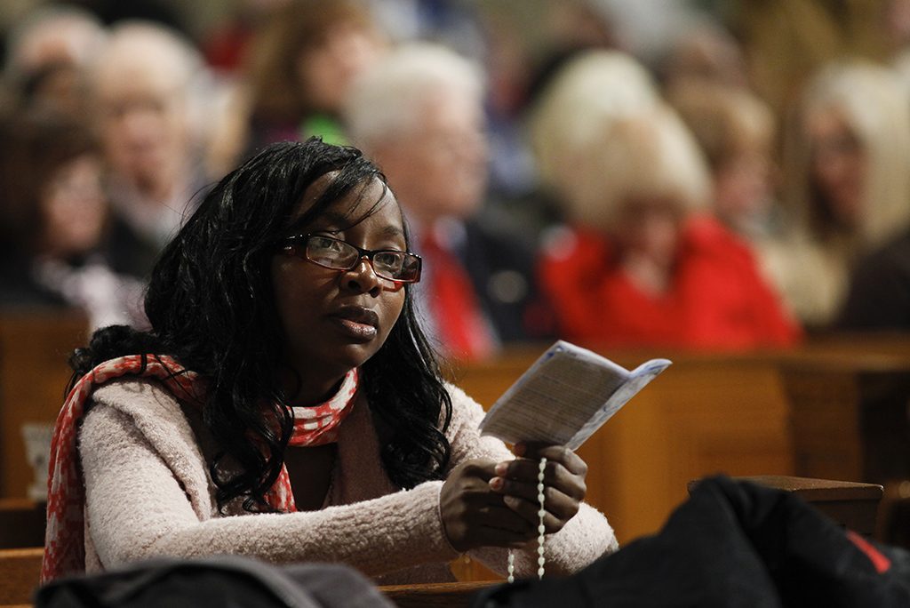 Woman prays during mass celebrating canonization of St. Kateri Tekakwitha