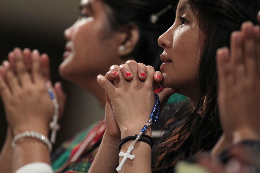 Hmong Catholics pray the rosary during a pilgrimage