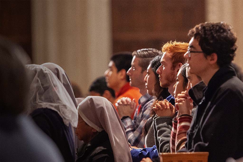 students pray during mass