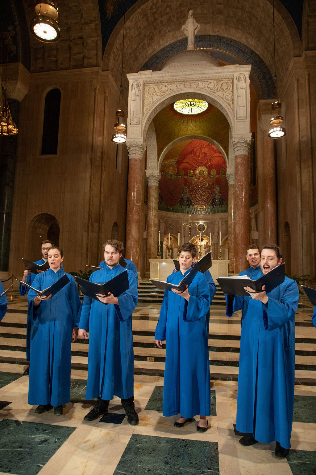 Members of the Basilica choir singing in front of the Upper Church baldachin