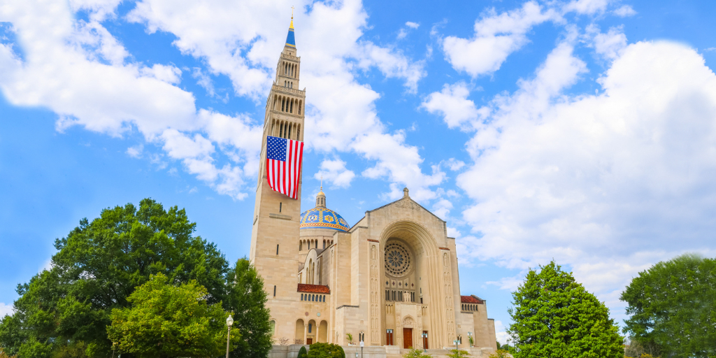 The National Shrine exterior during daylight with a flag flying