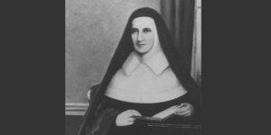 Ven. Catherine McAuley is pictured sitting, wearing a habit with a book in hand