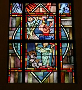 A stained glass window depicts Cain and Abel