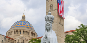 A statue of Mary with the US flag in the background