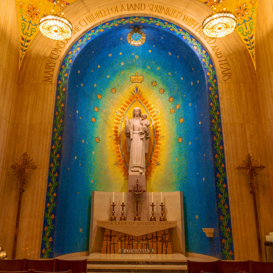 A marble statue of Mary on a yellow and blue mosaic background