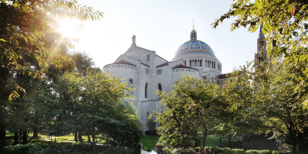 The exterior of the National Shrine in daylight, trees in the foreground