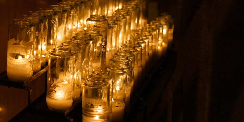 Vigil candles burn in dark church room