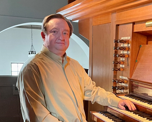Headshot of Thomas Vozzella by an organ