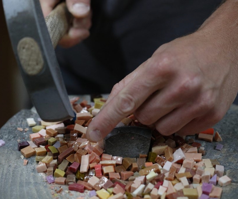 Mosaic artist chisels tiles for Trinity Dome